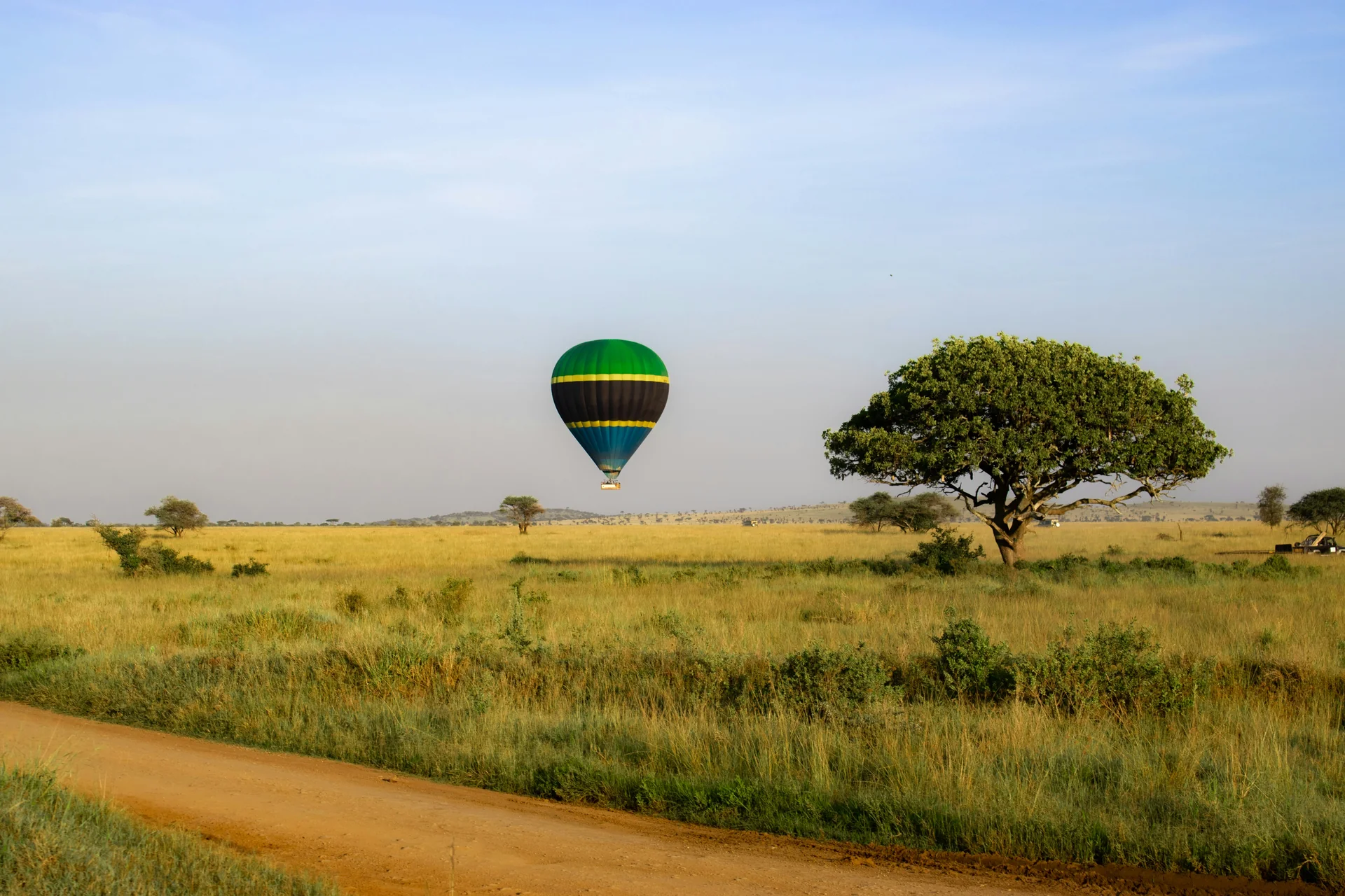Globo aerostático con los colores de la bandera de Tanzania sobre la sabana