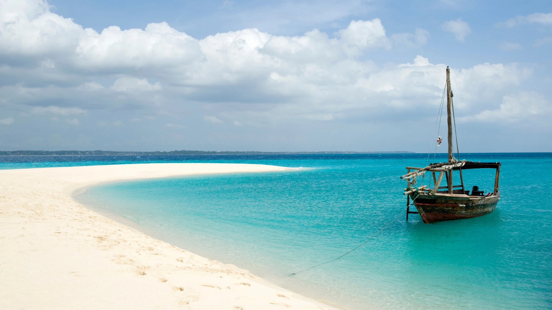 Eine traditionelle Dhau neben einer weißen Sandbank auf Sansibar